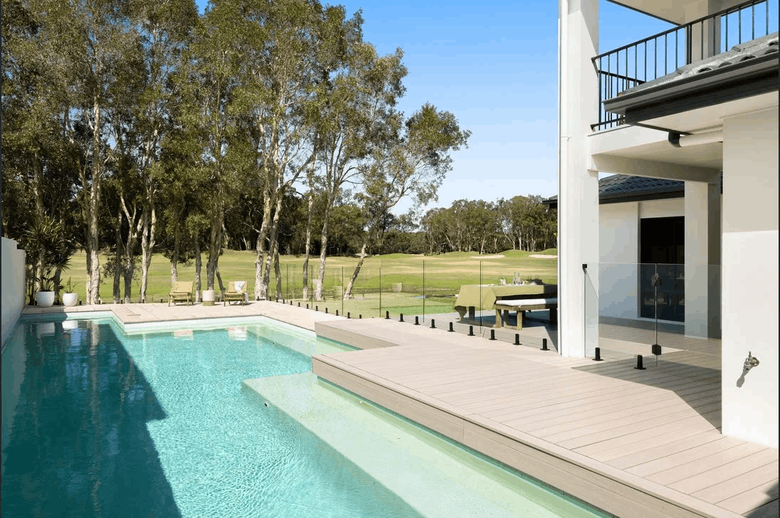 Frameless glass pool fence in a treed backyard