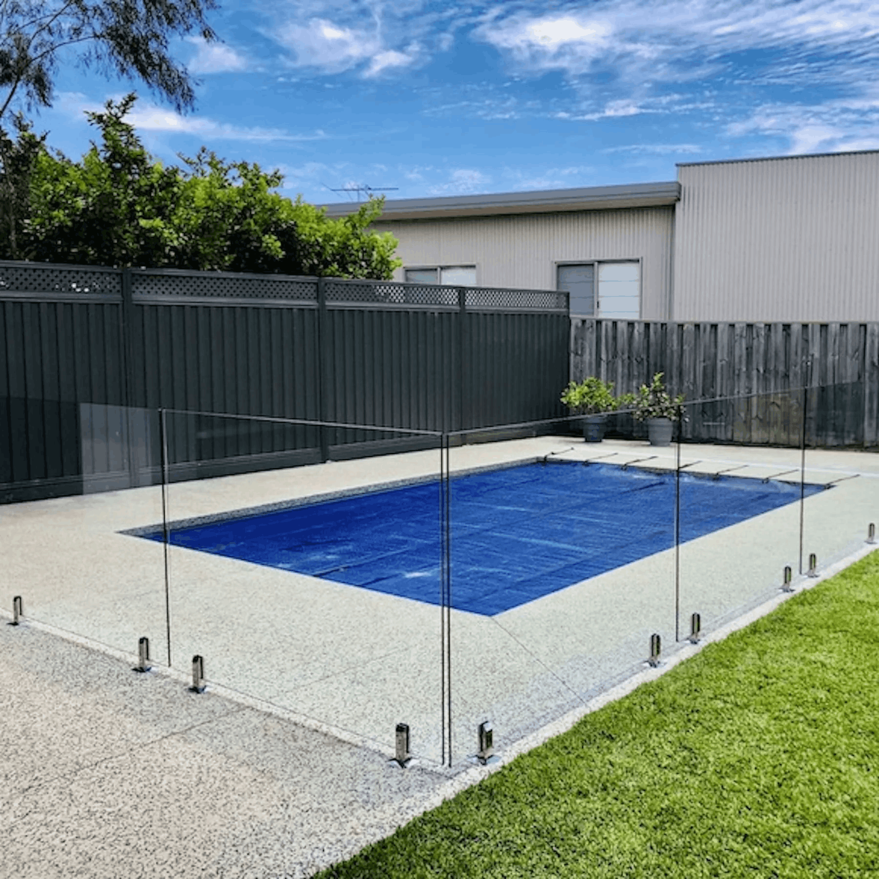 Frameless glass pool fence with a pool cover
