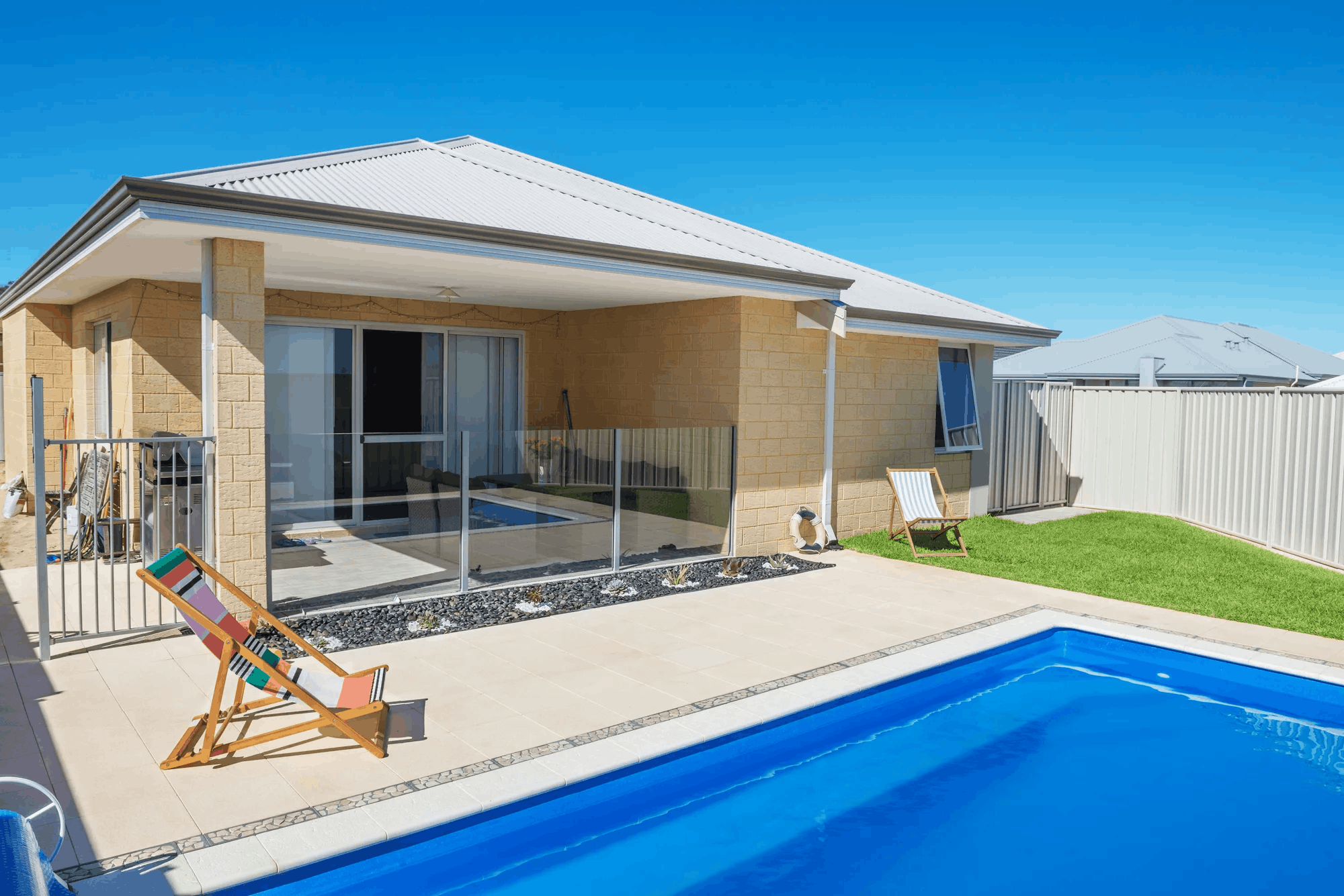Frameless glass pool fence on an elevated deck with a view
